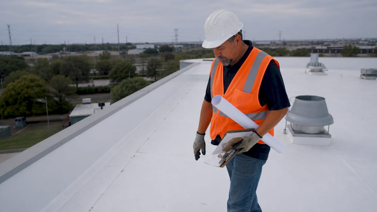 Technician inspecting Texas commercial TPO roof